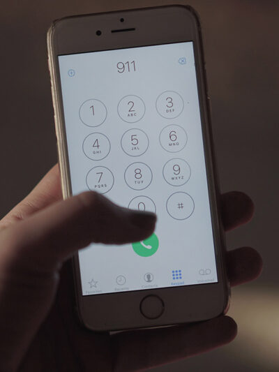Close up of a hand dialing 911 on a cell phone