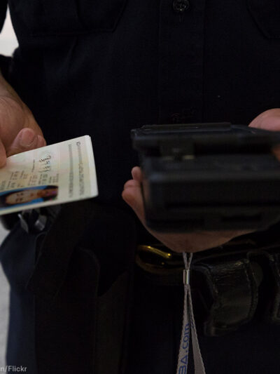 A CBP officer checks a passenger's ID