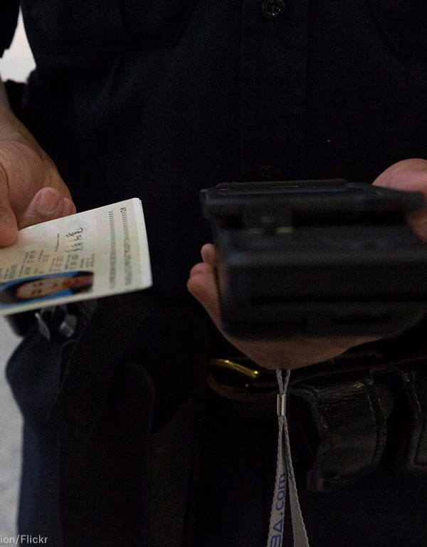 A CBP officer checks a passenger's ID