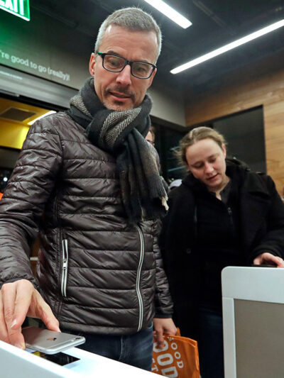 A customer scanning the Amazon Go cellphone app at the entrance of an Amazon Go store