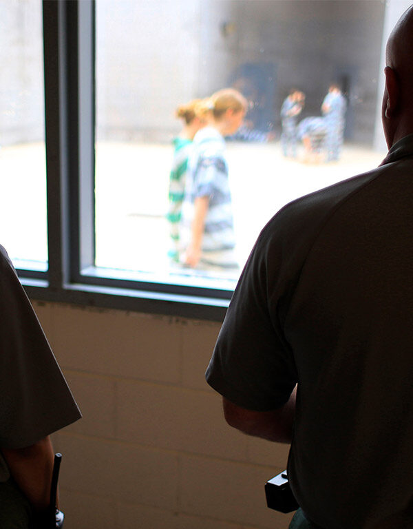 Deputies observe incarcerated people at in a women's detention area