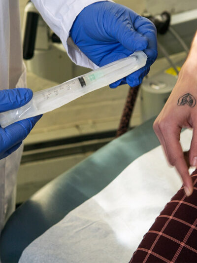 A doctor showing a patient a syringe used to inject testosterone