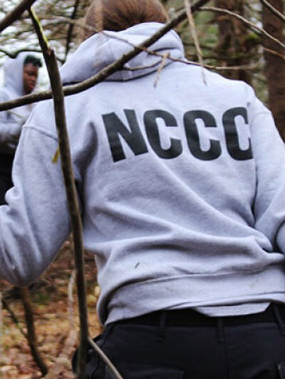 A NCCC worker hauling branches