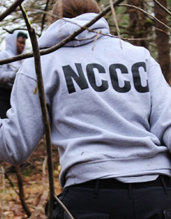 A NCCC worker hauling branches