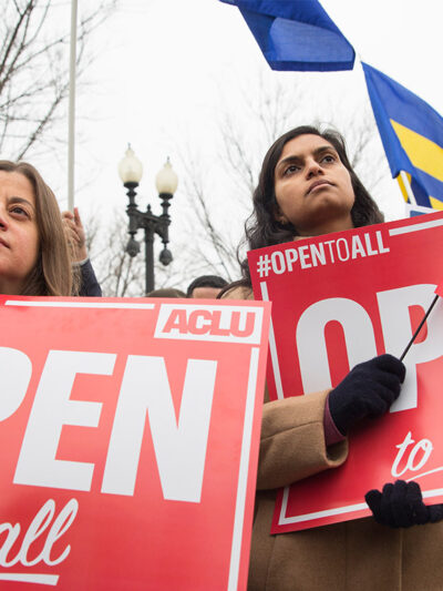 Demonstrators holding signs with the message 'Open to All"