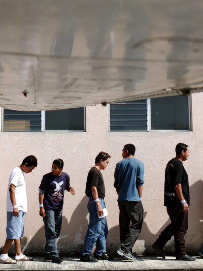 A line of Guatemalans arriving outside of the Guatemala City airport after having been deported from the US back to Guatemala.
