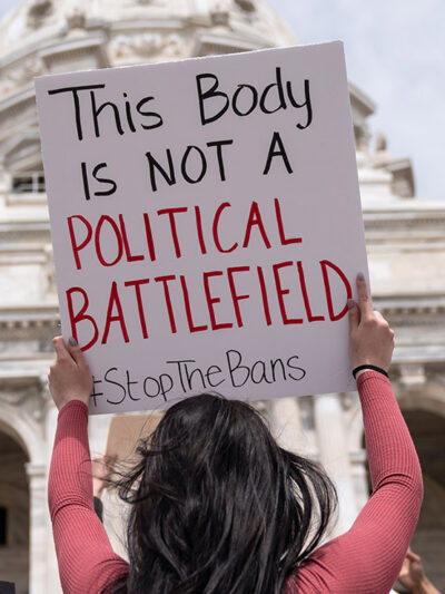 A pro-choice demonstrator with a sign with the text "This body is not a political battlefield"