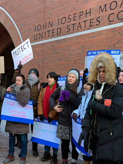 Protesters stand outside the federal courthouse where a hearing was scheduled for Northeastern University student Shahab Dehghani