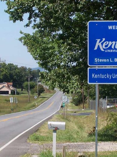 A Welcome to Kentucky road sign with the name of Governor Steven L. Beshear