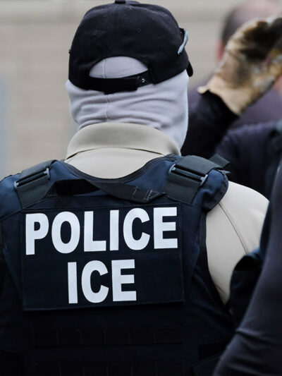 Back of an Immigrations and Customs Enforcement (ICE) officer's vest that reads "POLICE ICE." Taken in Portland, OR.