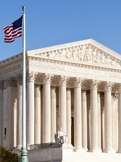 The front of the Supreme Court building in Washington DC on a sunny day.