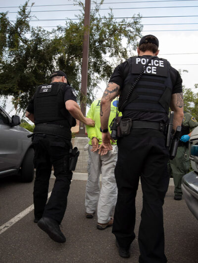 On a sunny day in California, two Immigration and Customs Enforcement (ICE) officers escort a man in handcuffs. Trump administration officials have confirmed plans for two new tactics in their anti-immigrant agenda.