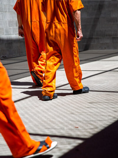 inmates walk the yard during recreation time in a county jail.