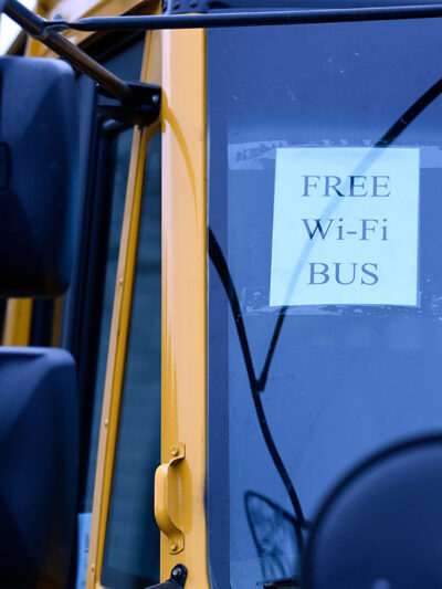A sign on a school bus displays "FREE WIFI BUS"