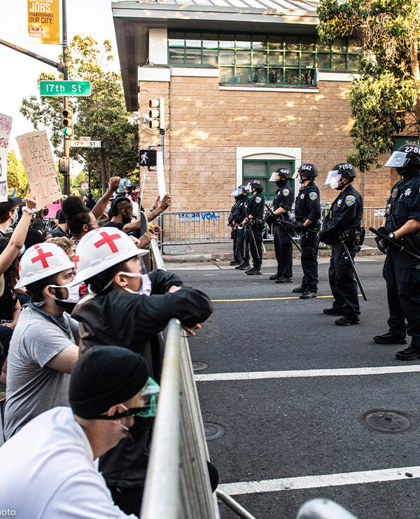 Protestors demonstrate in front of a line of police officers outside of Mission Police Station in San Francisco after the death of George Floyd