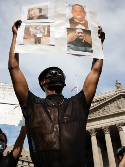 A protester holds up a sign with picutres of Black Americans who have been killed by police, taken in New York City June 2, 2020