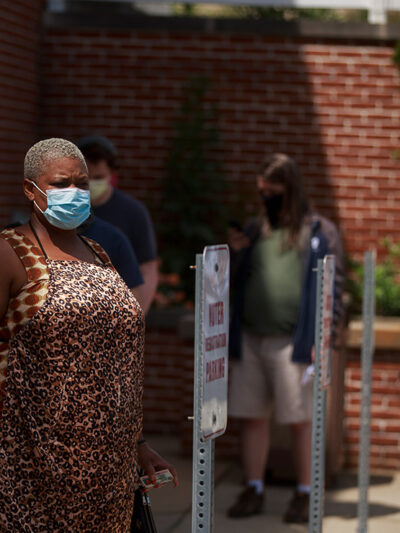Voters wearing face masks as a preventive measure wait in a line during an early voting in Monroe County, Indiana.