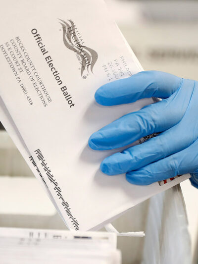 A worker processes mail-in ballots.