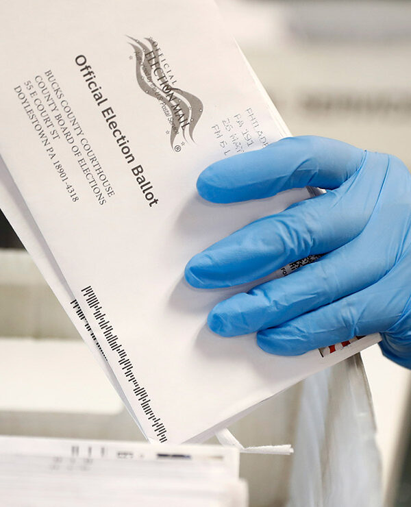 A worker processes mail-in ballots.