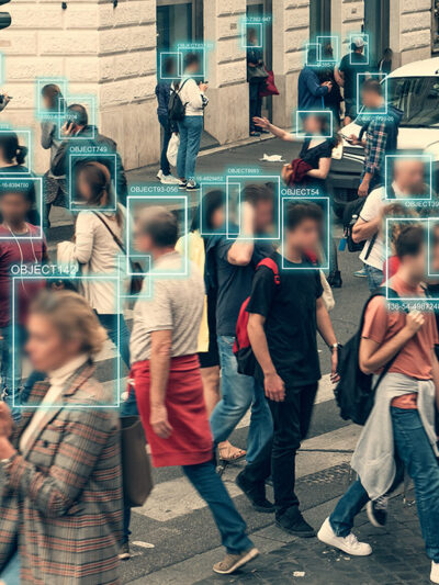Facial recognition software scanning people walking across a busy intersection.
