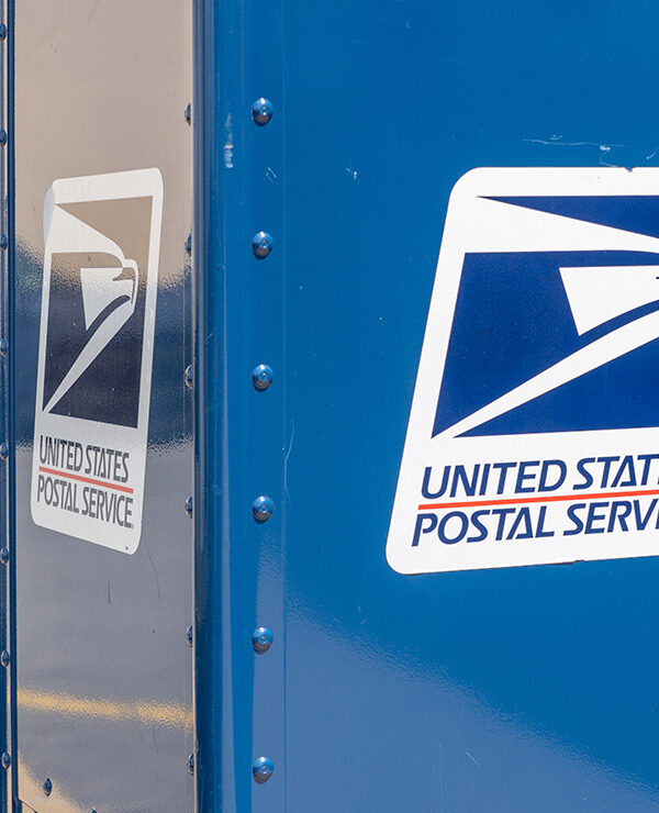 A blue United States Postal Service (USPS) collection box as seen on the street.