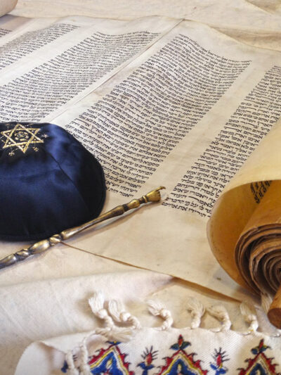 The Hebrew handwritten Torah, on a synagogue alter, with Kippah and Talith