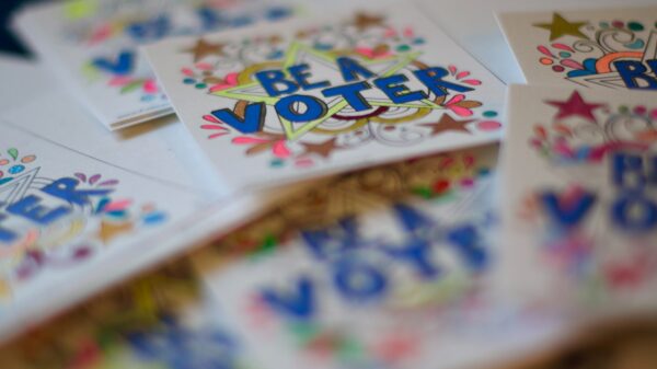 The words "Be a Voter" on a colorful sticker