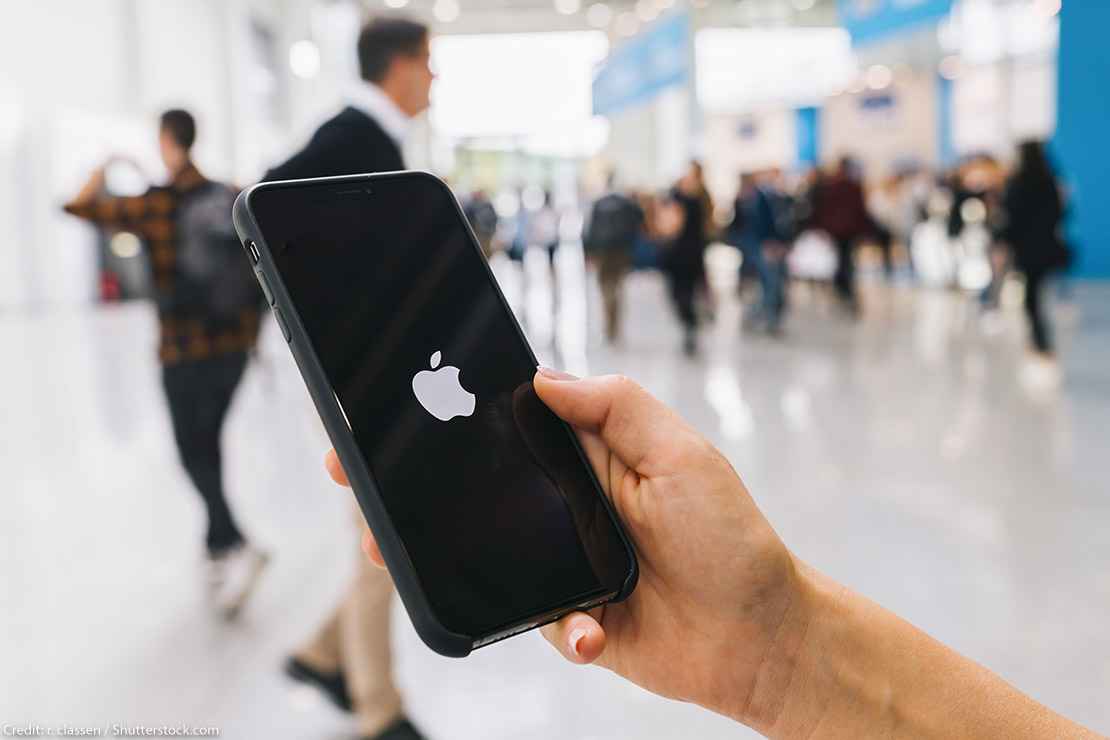 Person holding iPhone with Apple logo on screen