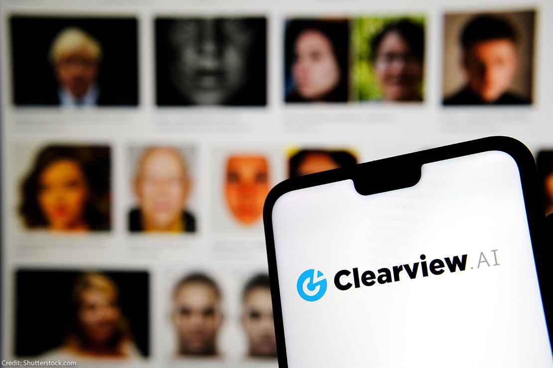 Clearview AI facial recognition software logo on the glowing screen and blurred faces from social media on the background