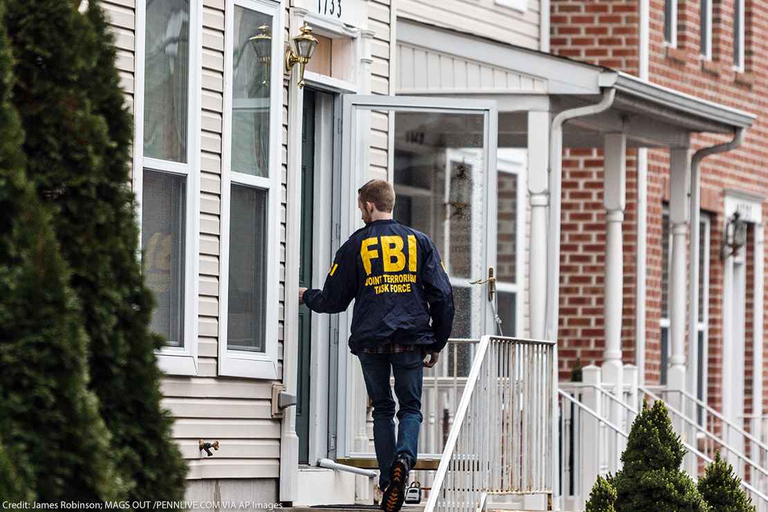 A member of the FBI enters a residence.