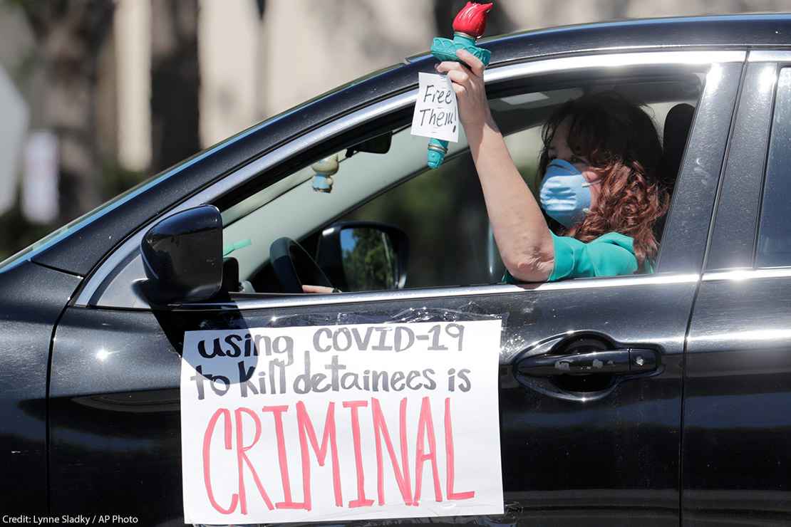 A woman drives in a caravan protesting conditions detainees face in ICE detention centers.