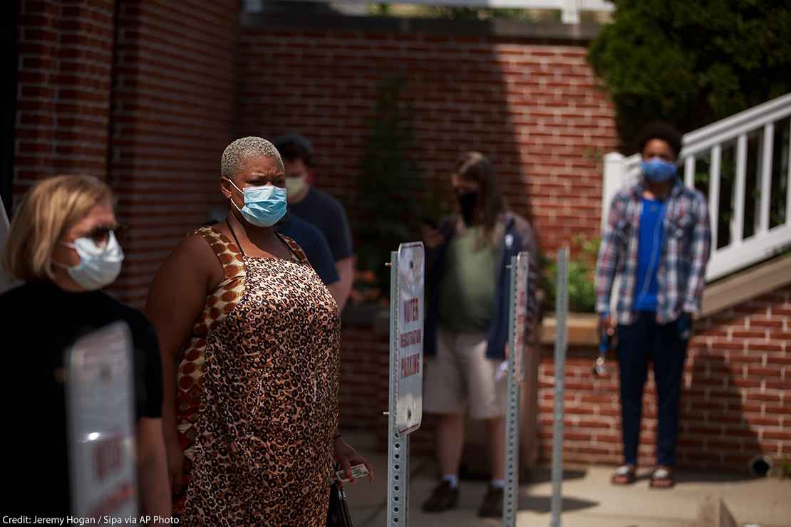Voters wearing face masks as a preventive measure wait in a line during an early voting in Monroe County, Indiana.