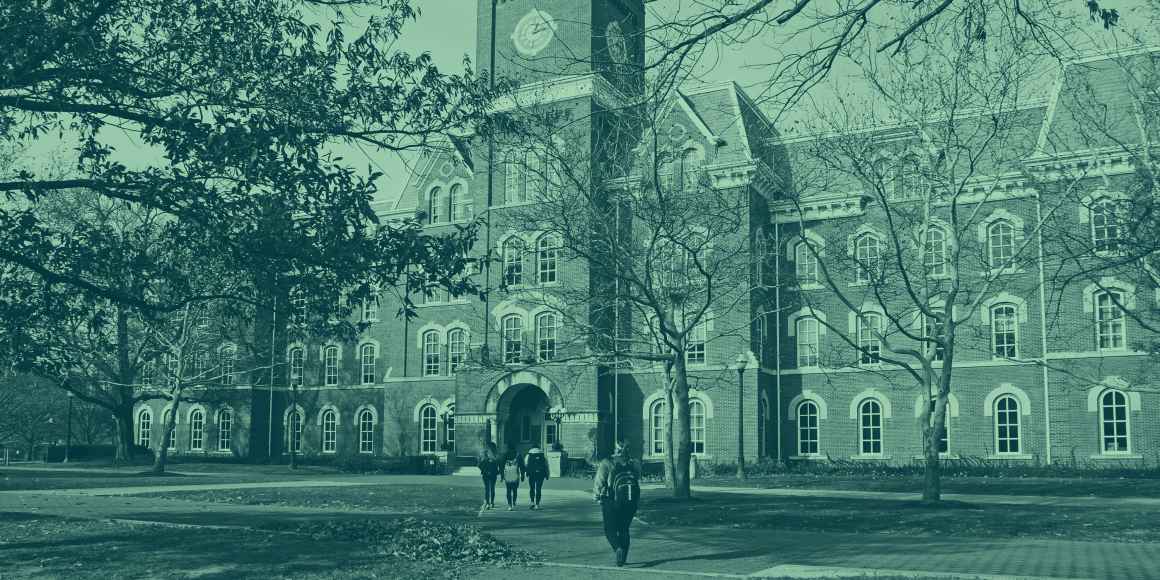 Green tinted picture of students walking on a college campus.