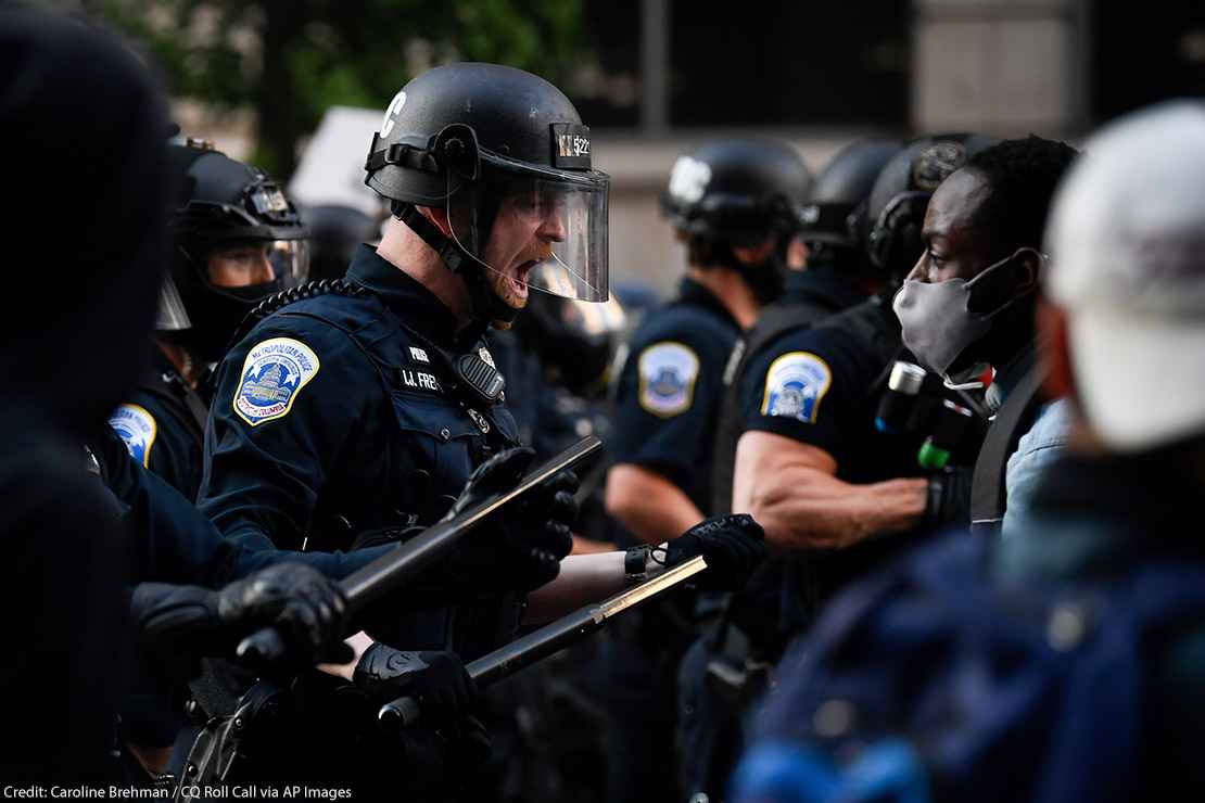 Police in riot gear shouts in black protestor's face as demonstrators gather to protest the death of George Floyd near the White House