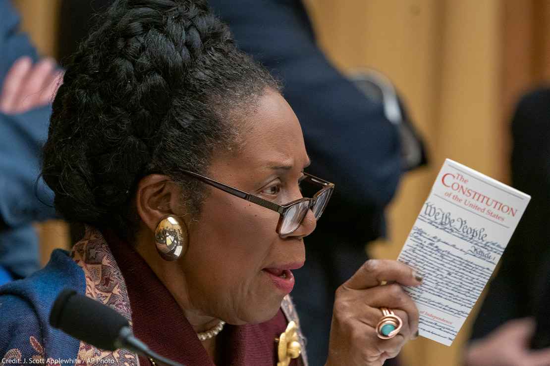 Rep. Sheila Jackson holds a pocket-size copy of The Constitution during a House committee hearing.