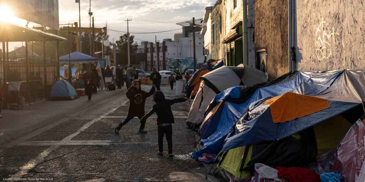 Two boys running around and playing outside of tents in Ciudad Juarez, Mexico.