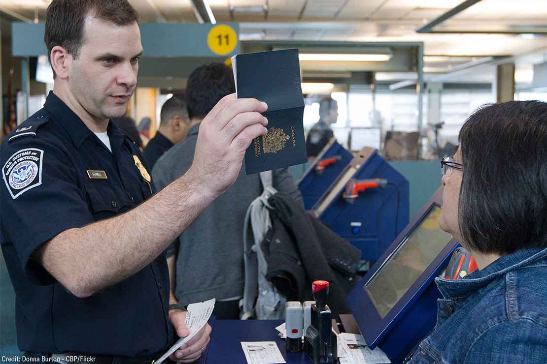 A CBP agent inspecting a passport