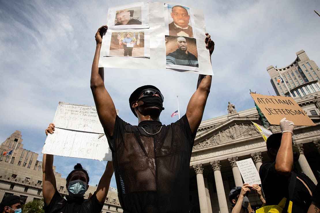 A protester holds up a sign with picutres of Black Americans who have been killed by police, taken in New York City June 2, 2020