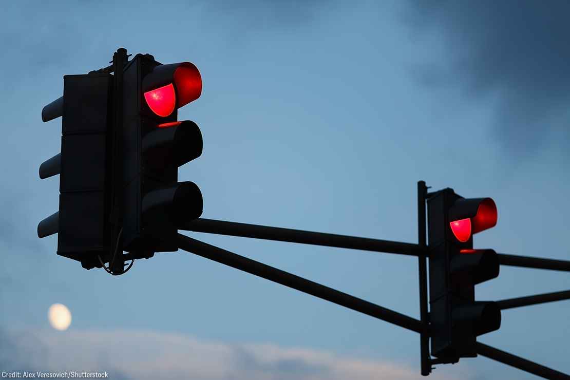 Traffic light with red light against the evening sky. Shallow depth of field.