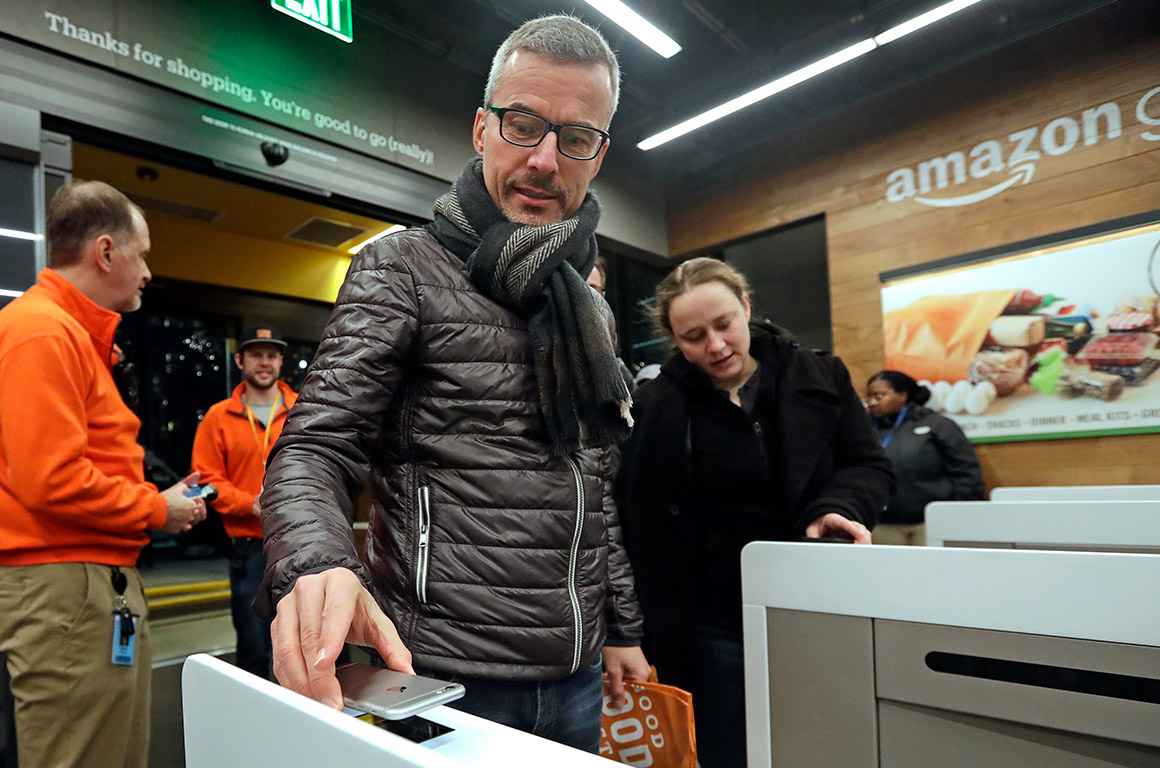 A customer scanning the Amazon Go cellphone app at the entrance of an Amazon Go store