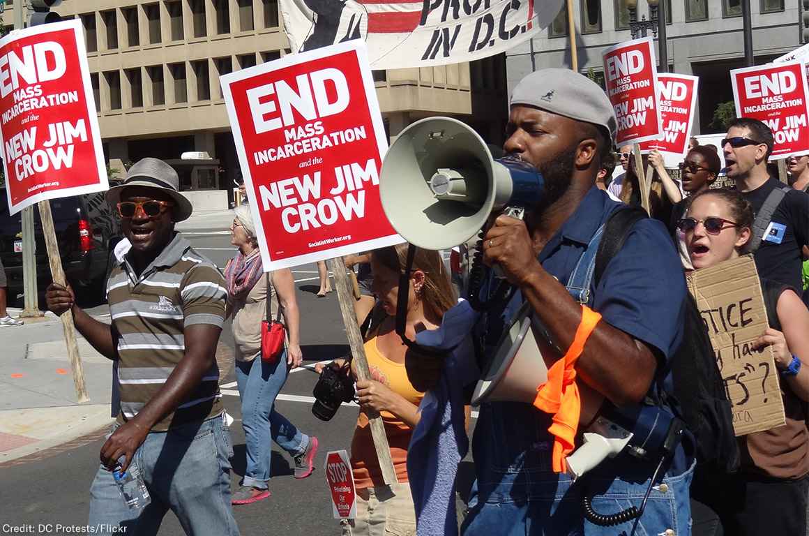 Demonstrators carry signs advocating an end to mass incarceration