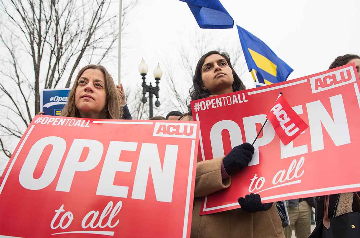 Demonstrators holding signs with the message &#039;Open to All&quot;