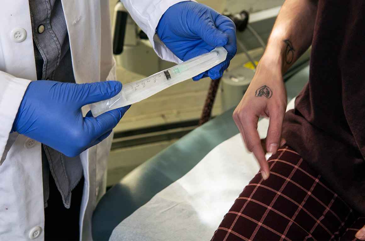 A doctor showing a patient a syringe used to inject testosterone