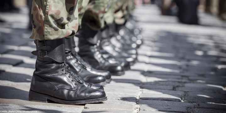 A row of boots belonging to military soldiers.